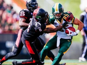 From left, Calgary Stampeders defenders Keon Raymond and Fred Bennett bring down Edmonton Eskimos receiver Nate Coehoorn during the Labour Day Classic on Monday, Sept. 1, 2014. The Stamps beat the visiting Eskimos 28-13.