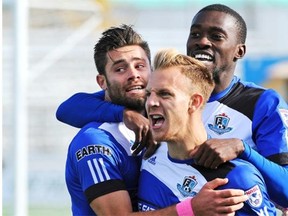 From left, Ritchie Jones, Neil Hlavaty and Tomi Ameobi celebrate an FC Edmonton goal against the Carolina Railhawks during a North American Soccer League game at Clarke Field on Oct. 12, 2014.