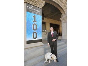 Garrett Turta, general manager of the Fairmont Hotel Macdonald Edmonton, stands in front of some newly installed banners at the hotel with his dog Smudge, in preparation for the celebration of the hotel’s 100th birthday.