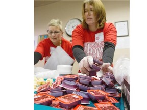 Gloria Sarchuk, left, and Tamara Thiessen prepare cranberry sauce packets during The Salvation Army’s annual Community Christmas Dinner. More than 1,000 people were expected to share a traditional turkey dinner with the help of 50 volunteers at the Salvation Army in downtown Edmonton on December 2, 2014.