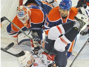 Goaltender Ben Scrivens and defenceman Boyd Gordon of the Edmonton Oilers combine to stymie a scoring attempt by Liam O’Brien of the Washington Capitals at Rexall Place on Wednesday. Scrivens made 32 saves in a 3-2 Oilers’ victory.