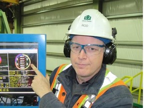 Rod Goldie, general manager of Edson Forest Products, shows a computer monitor that provides real-time information on logs being processed.
