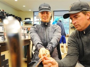 Golf pro Cam Martens talks to Kristen Monasterski about the proper hand grip during a lesson at the Windermere Golf & Country Club on Friday.