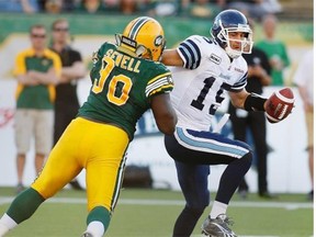 Toronto Argonauts quarterback Ricky Ray is sacked by Edmonton Eskimos’ Almondo Sewell during 2012 CFL action at Commonwealth Stadium.