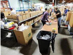 A group of volunteers helps sort donated items at the Edmonton Food Bank on Sept. 24, 2014. Soaring use of food banks is absurd in a province as rich as ours, writes Elizabeth Reid.