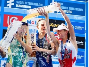 Gwen Jorgensen of the United States, middle, Emma Jackson of Australia and Kirsten Sweetland of Canada celebrate at the podium after the women’s World Triathlon Series sprint event at Hamburg, Germany, on July 12, 2014.