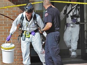 Hazmat team members exit the Canadian Blood Services building after a suspicious package was discovered aat 8249 114th St. in Edmonton, Tuesday, August 26, 2014. Police taped off the entrance to the building for about two hours.