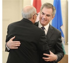 Health Minister Stephen Mandel is congratulated by Premier Jim Prentice during the swearing-in ceremony Monday at Government House. Neither man has been elected to the provincial legislature.