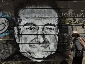 A woman walks past a mural depicting actor Robin Williams in downtown Belgrade on August 13, 2014.