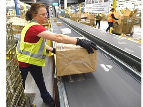 Heather Tiessen loads parcels at Canada Post’s Edmonton mail processing plant on Dec. 12, 2014.