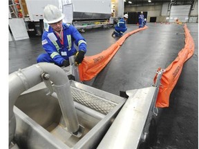 Instructor for Western Canadian Spill Services, Doug Gibson works a weir skimmer with booms during a staged emergency management exercise, that was created by the Canadian Energy Pipeline Association and its member companies, at the Edmonton Expo Centre on Wednesday, Sept. 24, 2014. The exercise is meant to prepare its workers for any potential oil spills.