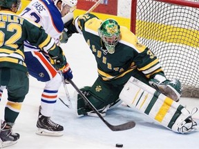 Jamie Crooks crashes into Edmonton Oilers forward Greg Chase, who can’t get the puck past Alberta Golden Bears goaltender Kurtis Mucha during pre-season action at Clare Drake Arena on Sept. 16, 2014, in Edmonton.