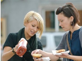 Jennifer Matyi (left) and Rebecca Wollenberg (right) enjoy a burger outside the Armoury Resource Centre in Old Strathcona on September 25, 2014 where Youth Connect 2014 was held.
