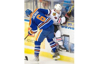Jesse Joensuu of the Edmonton Oilers hits Chicago Blackhawks’ Adam Clendening into the boards during Sunday’s National Hockey League pre-season game at Saskatoon.