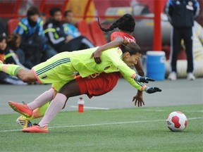 Kadeisha Buchanan of Team Canada hauls down Yuki Ogimi of Japan at Commonwealth Stadium in Edmonton. Both national teams were playing a friendly match as a tune-up for the Women’s World Cup in 2015. Shaughn Butts/Edmonton Journal