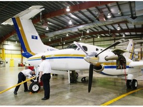 A King Air owned by the Alberta government sits in the hangar for maintenance work in 2004. The tail of a Dash-8 can be seen in the background at left.