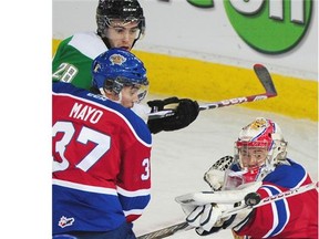 Oil Kings Patrick Dea makes a save with Gage Quinney 28, and Dysin Mayo in front as the Edmonton Oil Kings played the Prince Albert Raiders at Rexall Place in Edmonton, November 25, 2014.