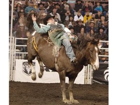 Kyle Bowers hangs on during the bareback riding competition on the second day of the Canadian Finals Rodeo in Edmonton on Thursday, Nov. 6, 2014.