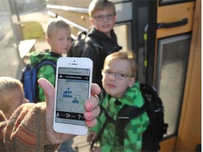 Leanne Bilodeau displays a school bus app on her smartphone while waiting for a school bus in southwest Edmonton with her husband Fabien and their sons Remy, Jack, Georges and Benjamin on Sept. 3, 2014. Edmonton Public School’s yellow buses are now equipped with GPS technology that allows parents to check whether their child’s bus is on time, using the Where’s My Bus? app on an iPhone.