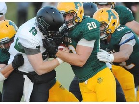 Linebacker Connor Ralph of the University of Alberta Golden Bears looks to the sidelines for the yardage markers while pushing Jeremy Long of the University of Saskatchewan Huskies back on a third and short yardage at Foote Field in Edmonton.