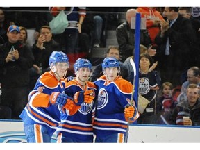 Mark Fayne (5),Taylor Hall (4) and Ryan Nugent-Hopkins (93) of the Edmonton Oilers, celebrate a first period goal against the Vancouver Canucks at Rexall Place in Edmonton.