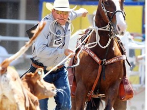 Matt Shiozawa, a tie-down roper from Chubbuck, Idaho, ties up his calf in a time of 7.3 seconds during the Calgary Stampede on July 9, 2014.