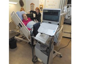 Medical radiologic technologist Marina Buziak uses a mobile X-ray machine on patient Rosemarie Hill at St. Michael’s care facility in Edmonton on Oct. 15, 2014.
