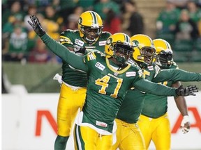 Members of the Edmonton Eskimos defensive line, including Odell Willis, centre, celebrate a sack against the Saskatchewan Roughriders at Commonwealth Stadium on Friday, Sept. 26, 2014.