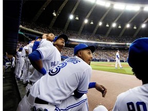 Members of the Toronto Blue Jays watch as a pop fly sails in to the stands during preseason Major League Baseball play against the New York Mets at the Olympic Stadium in Montreal on Friday.