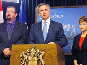 On Monday, Alberta Premier Jim Prentice announced at legislature that opposition Wildrose members Ian Donovan, left, and Kerry Towle, right, have crossed the floor to join his Progressive Conservative caucus.