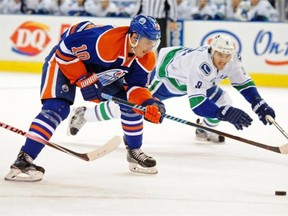 Nail Yakupov of the Edmonton Oilers skates in on the Vancouver net despite the efforts of Canucks defenceman Chris Tanev in a National Hockey League game at Rexall Place on Nov. 1, 2014.