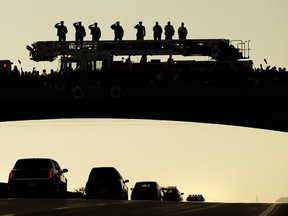 Supporters pay tribute as the body of Cpl. Nathan Cirillo is transported from Ottawa to Hamilton, along the Highway of Heroes in Port Hope, Ont., on Oct. 24, 2014. Canadians are mourning the loss of Cpl. Nathan Cirillo, the army reservist who was shot dead as he stood guard before the Tomb of the Unknown soldier on Wednesday.