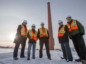 Nicole Howard, project architect for the City of Edmonton, Manuel Quilala, Bus Facilities Project Manager for ETS, Terry Bohaichuk, project officer, City of Edmonton, Holmann Wong, director bus and LRT operations for ETS, George Kuhse, divisional supervisor, bus operations for ETS, stand with the giant chimney in the old meatpacking district of Edmonton near Fort Road and the Yellowhead Highway. The city is making a $200-million investment to develop the empty land and build a bus facility