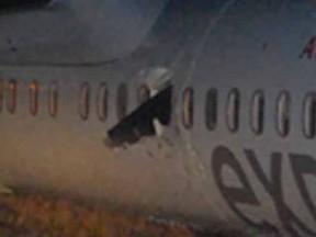 A propeller is seen lodged into the side of the plane that had a rough landing at Edmonton International Airport on Thursday Nov. 6, 2014.
