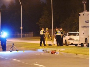 An investigator's camera flash goes off at the scene of a fatal pedestrian collision in west Edmonton on Thursday, Aug. 28, 2013.