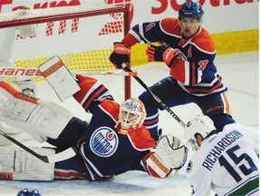 Oilers goalie Ben Scrivens, left, and Taylor Hall, right, make a save on a shot from Brad Richardson, bottom right, during Vancouver’s 5-4 win against the Edmonton Oilers at Rexall place in Edmonton on Wednesday, Nov. 19, 2014.
