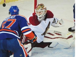 Oilers' Benoit Pouliot scores on Coyotes goalie Devan Dubnyk, right, during Edmonton's pre-season game against the Arizona Coyotes at Rexall place in Edmonton, October 1, 2014.