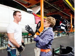 Ontario Premier Kathleen Wynne speaks with chassis production team member Mark Prentice during her tour of the General Motors Oshawa Assembly Plant, Friday, February 7, 2014. The province’s manufacturing base is seeing signs of life.