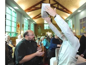 Orest Myroon holds up the time capsule removed from a cornerstone at Augustana Evangelical Lutheran Church in Edmonton, Oct. 19, 2014. The capsule was placed in the cornerstone during the church’s dedication ceremony in 1952. The church is closing and also celebrating its 85th anniversary, and the congregation opened the capsule during the service ceremony.