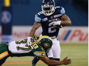 Otha Foster, bottom, of the Edmonton Eskimos makes a tackle on Chad Owens of the Toronto Argonauts during their game at Rogers Centre in Toronto on Saturday, Oct. 4, 2014.