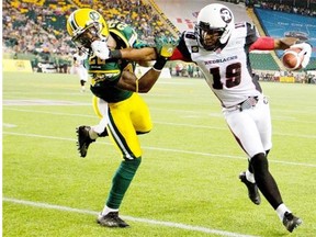 Ottawa Redblacks receiver Paris Jackson, right, tries to get away from Edmonton Eskimos cornerback Joe Burnett during a Canadian Football League game at Commonwealth Stadium on July 11, 2014.