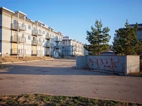 The Penhorwood condominium complex, now surrounded by a fence, is covered with graffiti and shattered glass.