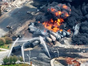 In this July 6, 2013 file photo, smoke rises from railway cars carrying crude oil after derailing in downtown Lac Megantic, Quebec. John Ray says cuts to Transport Canada and other agencies have been downplayed, much to our detriment.