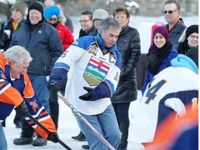 Premier Jim Prentice, centre, plays ball hockey outside the Banff Springs Hotel ahead of the Tory party’s annual general meeting on Friday, Nov. 14, 2014.