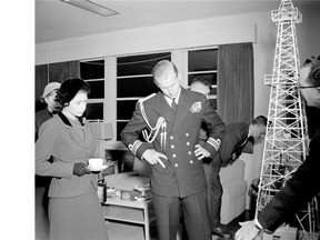 Princess Elizabeth and Philip look at an oil derrick replica at the boardroom of Imperial Oil Canada.