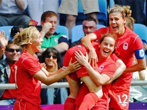 Rhian Wilkinson lifts Diana Matheson up on her shoulders to celebrate her teammate’s goal in extra time that allowed Canada to beat France 1-0 and win the bronze medal at the 2012 London Olympics.