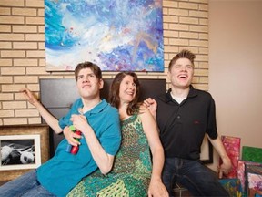Roma Kurtz has two sons with autism, both of whom are participating in The Art of Autism, an upcoming sale and auction at the Glenrose Rehabilitation Hospital. Roma, shown inside the family home in St. Albert on Sept. 22, is flanked by son Ben, left, who is a photographer, and Grant, right, who paints.