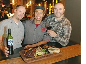 Rostizado Restaurant owners Chris Sills, left, and Daniel Braun, right, with chef Edgar Gutierrez with the mixed rotisserie platter for two (half chicken, half pork) and the Navarro Lopez Old Vines Tempranillo Pergolas wine