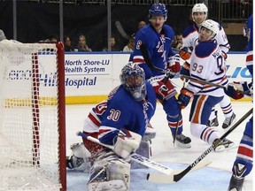 Ryan Nugent-Hopkins of the Edmonton Oilers looks back to see his shot hit the back of the net behind New York Rangers goaltender Henrik Lundqvist early in the first period of Sunday’s National Hockey League game at Madison Square Garden in New York.