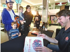 Ryan Smyth, former Edmonton Oilers winger, sign copies of the book, It's Our Game: Celebrating 100 Years of Hockey Canada, for the Gowan family, at West Edmonton Mall on Saturday.